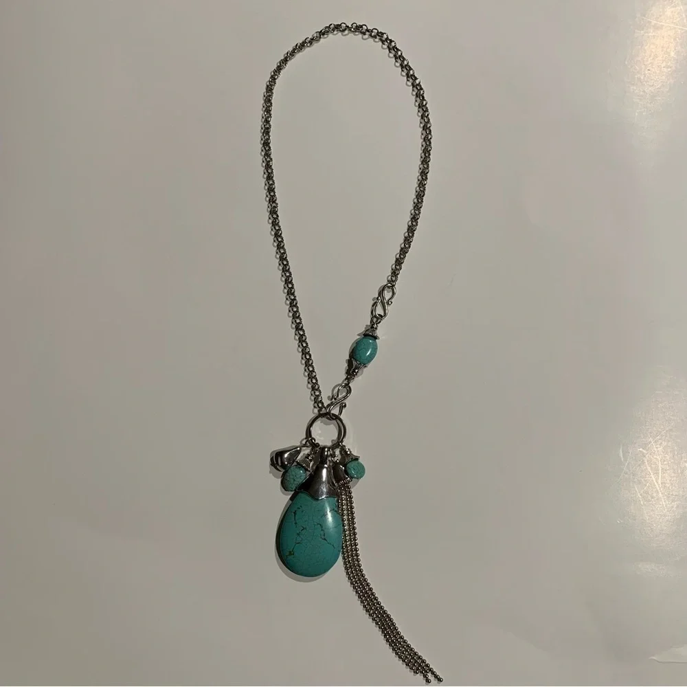 Silver tone and turquoise necklace with oversized pendant and charms.